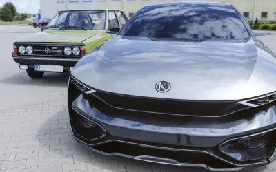 Nowoczesny concept car obok klasycznego Polskiego Fiata 125p. Przyszłość i historia polskich marek samochodów w jednym kadrze.