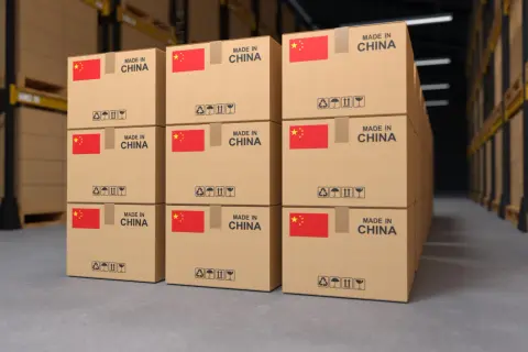 Stosy kartonów z napisem "MADE IN CHINA" i flagą Chin, gotowe do wysyłki. Każdy karton ma symbole ostrzegawcze, jak przy transporcie morskim, co może być podstawą do wystawienia konosamentu.