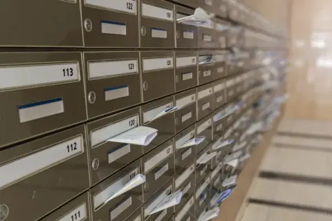 Rząd numerowanych skrytek pocztowych, niektóre z listami. Wyobraź sobie, że każdy z nich ma swój unikalny kod pocztowy Warszawa.