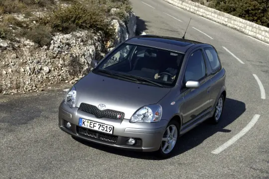 Szary Yaris TS zgrabnie pokonuje zakręt na górskiej drodze.