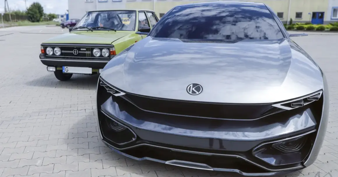 Nowoczesny concept car obok klasycznego Polskiego Fiata 125p. Przyszłość i historia polskich marek samochodów w jednym kadrze.